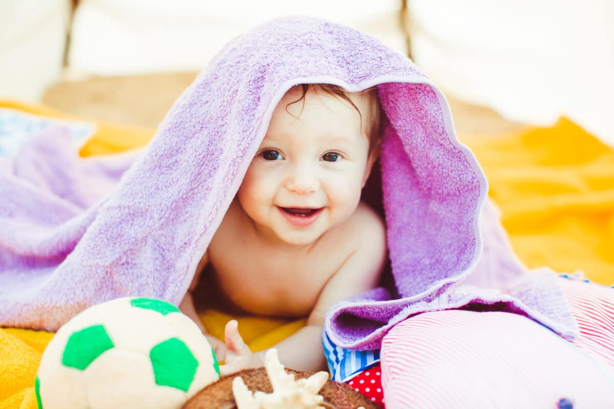 toddler-boy-lying-covered-with-purple-towel-1200x800.jpg