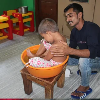 Avagaham, an Ayurvedic therapy for autism, where the child is immersed in a warm herbal bath or oil to provide therapeutic benefits. The therapy promotes relaxation, improves sensory integration, and relieves constipation and urinary infections.